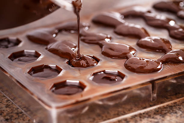 Poner el chocolate en molde - foto de stock
