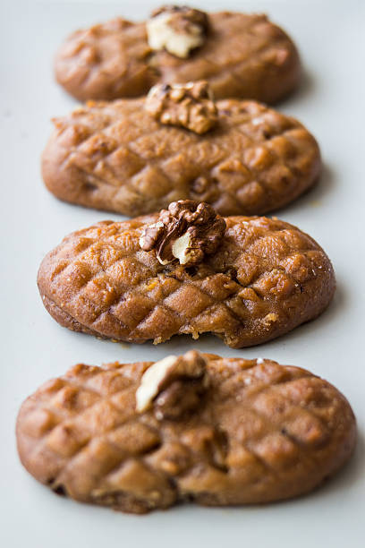Turkish Dessert Kalburabasti / Sekerpare with wallnuts in a white plate.