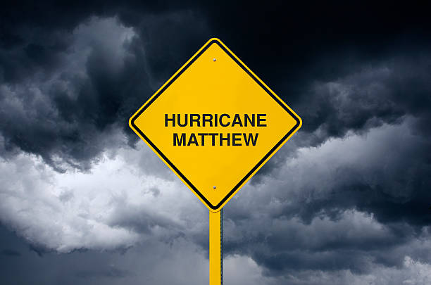 istock Caution Sign in Front of Storm Clouds Warning Hurricane Matthew 612732624