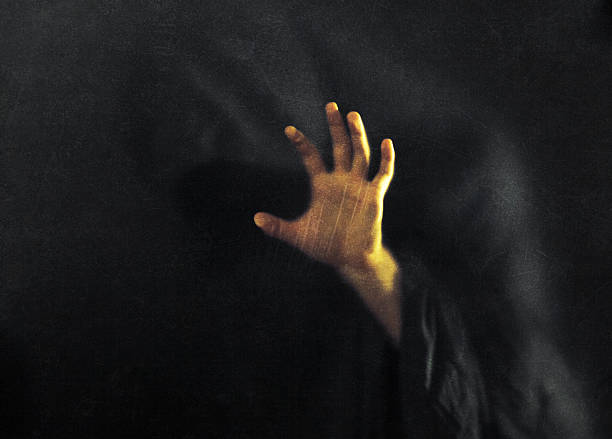 istock Shadowy figure behind dusty scratched glass 612733784