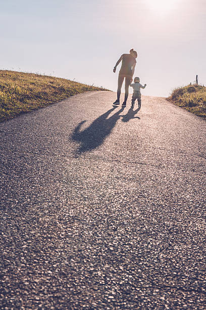 istock Baby walking with help of its parents - first steps 612736464