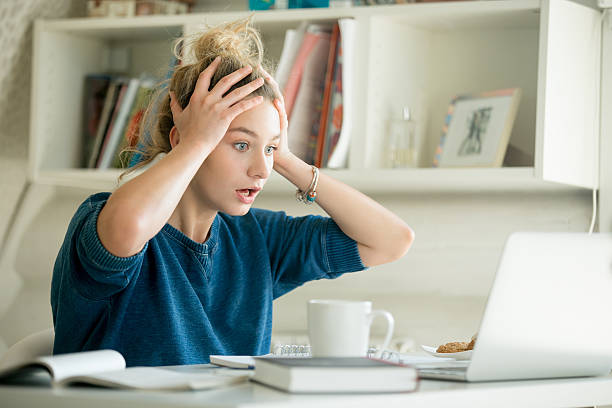 portrait of an attractive woman at table grabbing her head - frustration emotional stress surprise women imagens e fotografias de stock