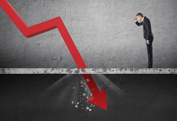 Businessman looking down at the falling red arrow destroying a Businessman looking down at the falling red arrow destroying a concrete barrier. Collapse and drop. Fall and depreciation. Regression and deterioration. Crisis. financial crises stock pictures, royalty-free photos & images