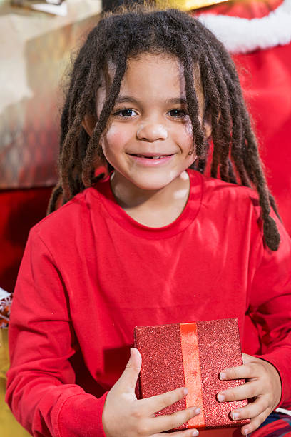 istock Little boy holding Christmas gift in red box 612737112