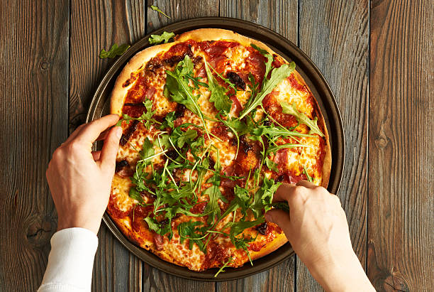istock Home made pizza on wooden table 612737982