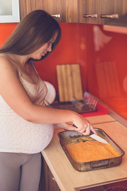 istock Pregnant woman cutting cake 612738650