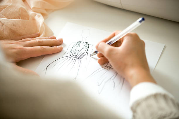 mani disegnando uno schizzo di design dell'abbigliamento - sewing textile garment industry foto e immagini stock