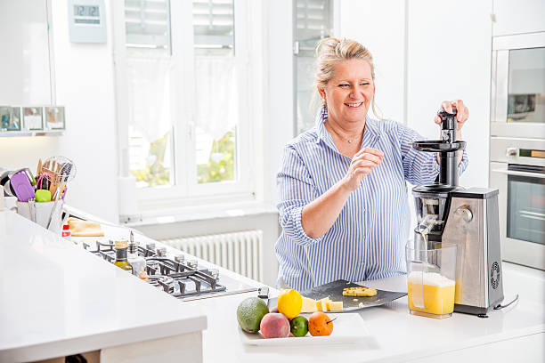 istock Woman using an Electric Juicer in her Kitchen 612739412
