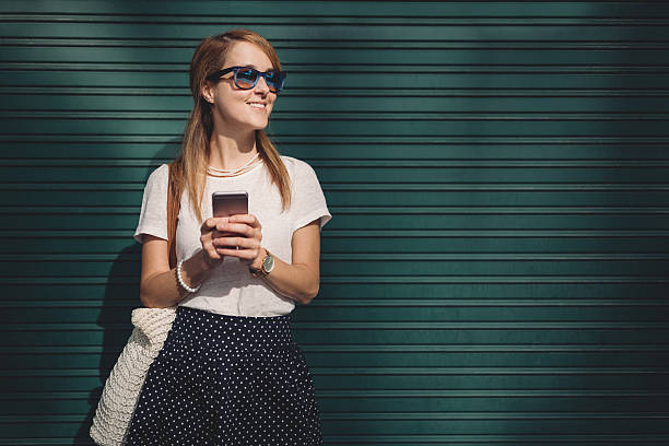 mulher mandando sms e sorrindo para alguém - women businesswoman elegance skirt - fotografias e filmes do acervo