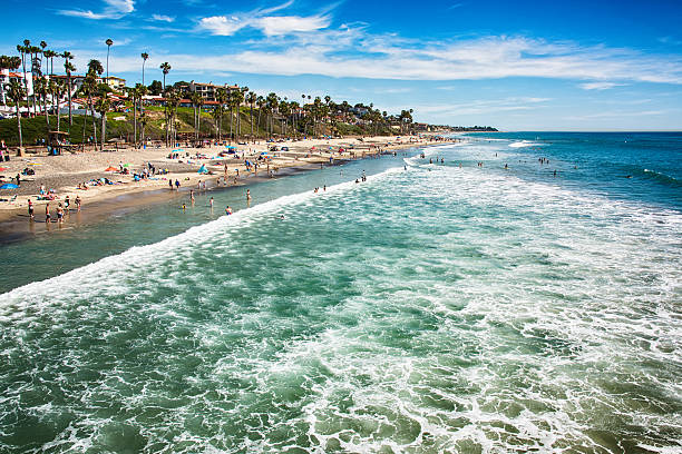 San Clemente, Southern Orange County California San Clemente, United States - March, 14, 2015:  Waves crashing along the crowded beach of San Clemente, Calfornia, during a warm spring day san clemente california stock pictures, royalty-free photos & images