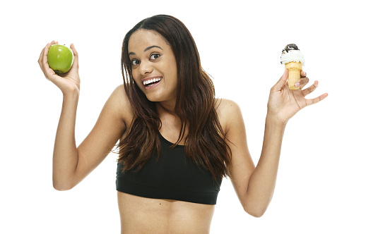 Smiling woman holding apple and ice cream