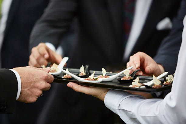 manos de hombres tomando aperitivos gourmet servidos por camarero profesional - food service industry fotografías e imágenes de stock