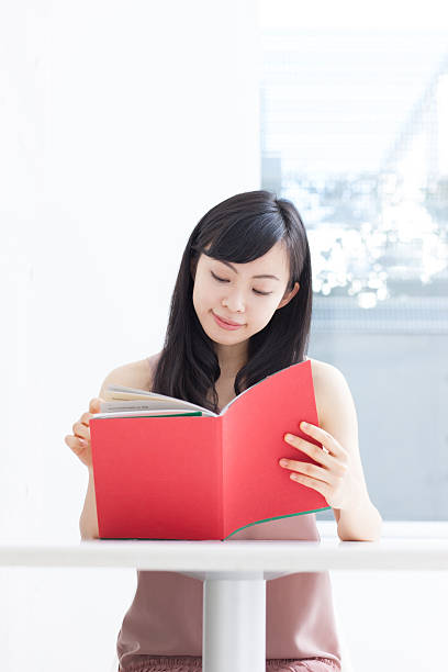 istock Japanese woman reading a book 612749700