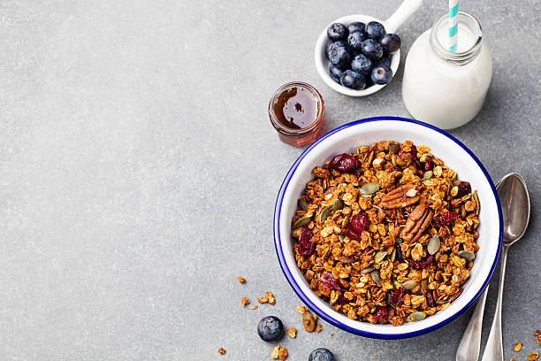 colazione sana. muesli freschi con zucca, noci pecan, sciroppo d'acero - honey caramel syrup fruit foto e immagini stock