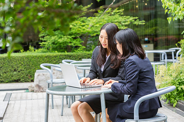 istock Young Corporate Japanese Business Women Working Outdoors With Computer 612754092