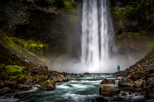 Hombre de pie cerca de la enorme cascada. photo