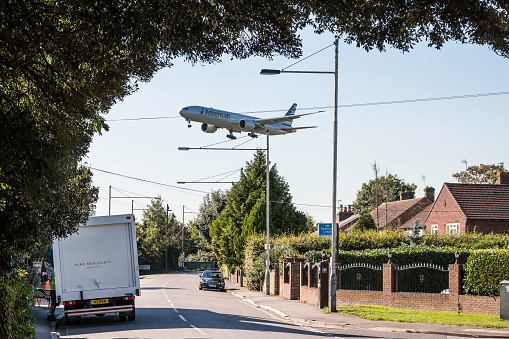 London, Heathrow, United Kingdom - October 3, 2016: American Airlines plane approaching to London Heathrow airport, low above housing estate.