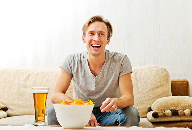 istock Happy young man watching sports on tv 612756964