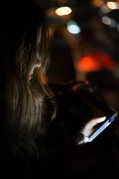 istock Girl using smart phone at night outdoors 612759074