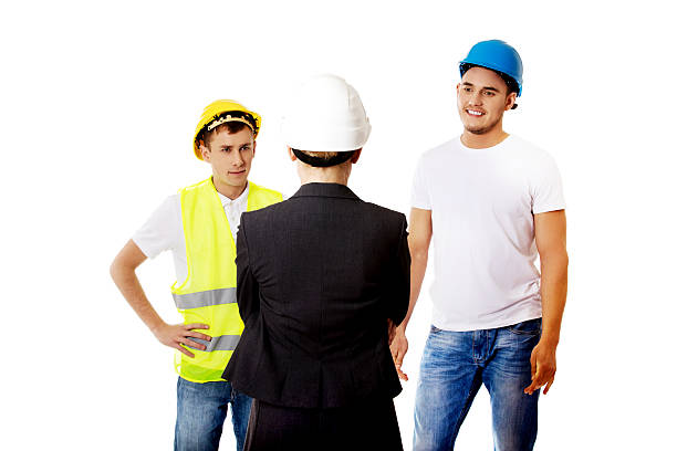 female engineer talking with two builders - violence hat toughness blue imagens e fotografias de stock