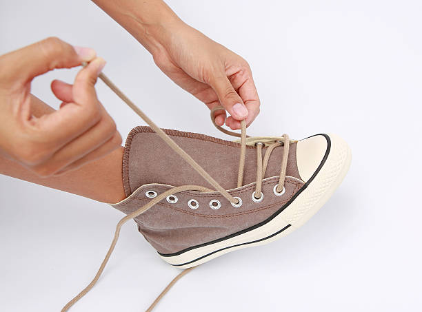 istock Tie her shoes canvas Sneakers on white background 612816592