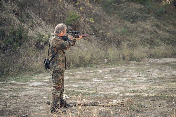 istock Older hunter with a hunting rifle 612819360