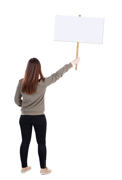 istock Back view woman showing sign board. 612821702
