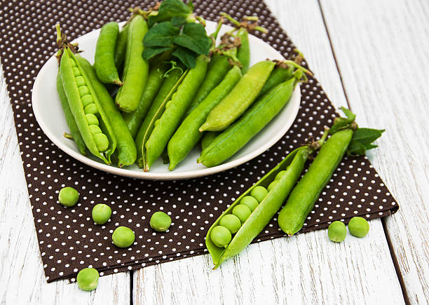 petits pois sur une table - pea pod photos et images de collection