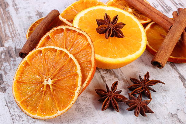 istock Dried and fresh orange with spices on old wooden background 612823190