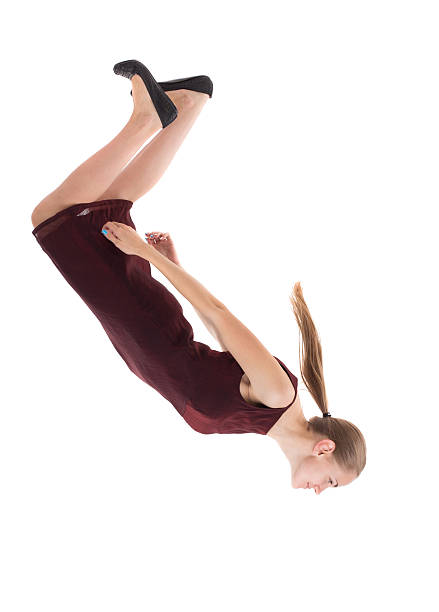 Balancing young woman. or dodge falling . Balancing young woman. or dodge falling woman. Rear view people collection. backside view of person. Isolated over white background. A girl in a burgundy dress falls head down. falling behind stock pictures, royalty-free photos & images