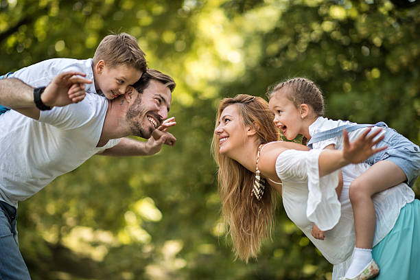 istock Young playful family having fun while piggybacking in nature. 612824490