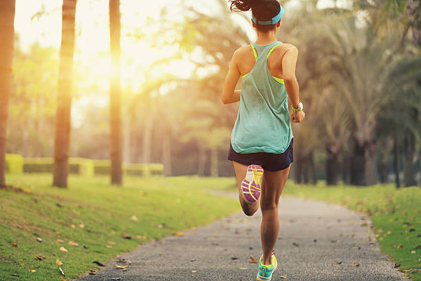 healthy lifestyle young sporty asian woman running at tropical park - park run bildbanksfoton och bilder