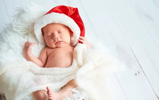 Photo of sleeper newborn baby in  Christmas Santa cap