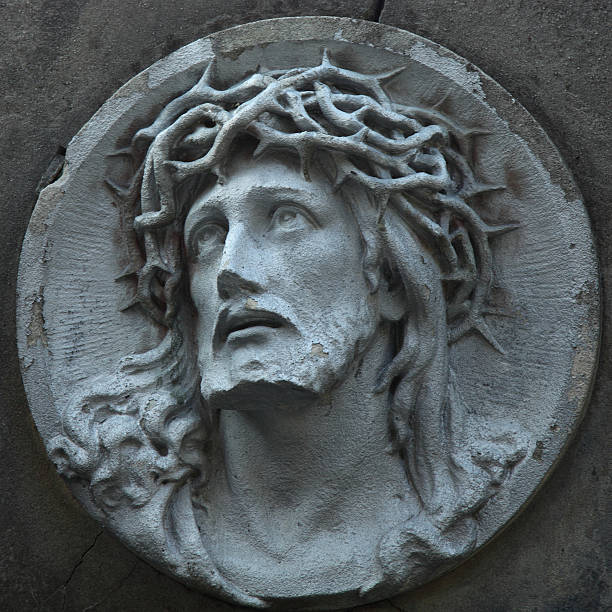 Jesus Christ statue against a background of gray stone with space for text