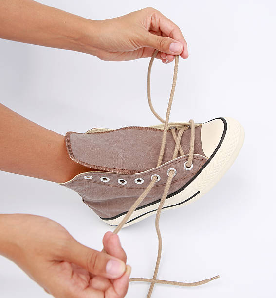 istock Tie her shoes canvas Sneakers on white background 612829356