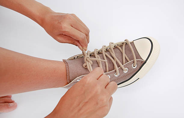 istock Tie her shoes canvas Sneakers on white background 612829706