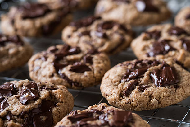 frisch gebacken vegan haferflocken schokolade chunk cookies auf kühlregal - plätzchen backen stock-fotos und bilder