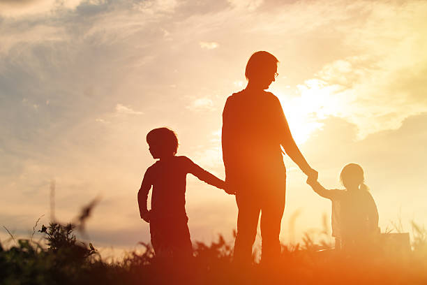 istock father with son and daughter walk at sunset 612835326