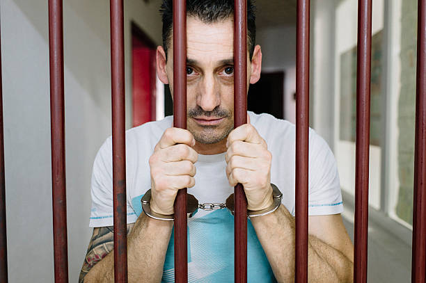 istock Caucasian Prisoner behind bars in Jail - Criminal Justice syste 612837256