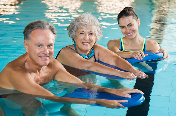 personas mayores activas en el fitness acuático - floating on water swimming pool men water fotografías e imágenes de stock