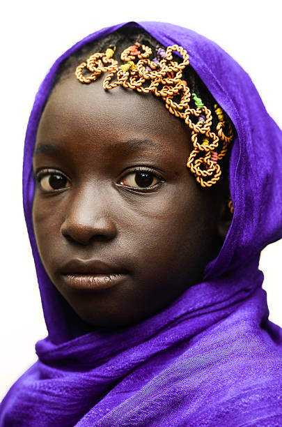 hermosa colegiala africana posando al aire libre con un pañuelo violeta en la cabeza - middle eastern ethnicity teenage girls women sadness fotografías e imágenes de stock