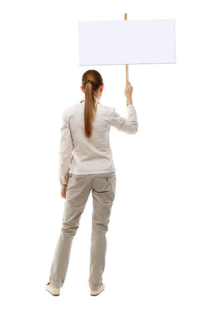 istock Back view woman showing sign board. 612841168