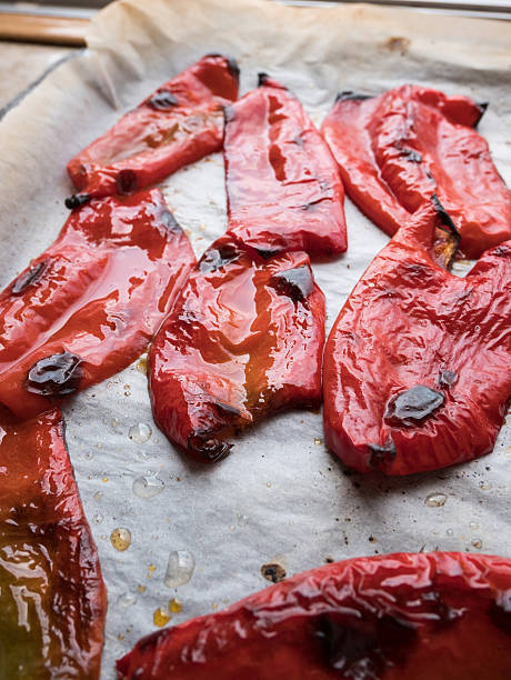 Shiny red peppers in baking tray - fotografia de stock