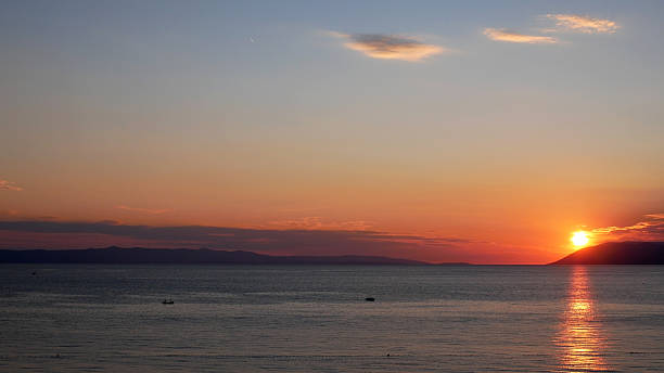 Pôr do sol sobre o mar calmo - fotografia de stock