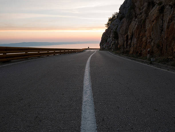 Estrada de montanha ao pôr do sol - fotografia de stock