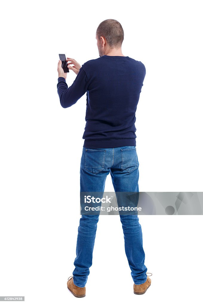 back view of man in suit  talking on mobile phone. back view of man in suit  talking on mobile phone.    rear view people collection. Isolated over white background. backside view of person. Man in black warm sweater holding a phone. Buttocks Stock Photo