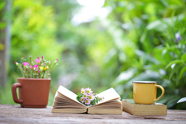 istock Notebook and yellow coffee cup with flowers  on wooden table 612844206