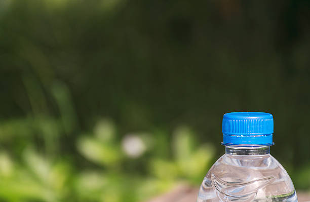 istock Plastic water bottle on wooden table texture with nature background. 612847322