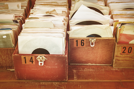 Retro styled image of boxes with vinyl turntable records on a flee market