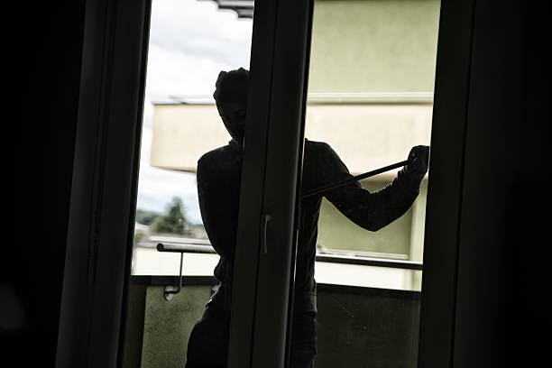 istock Burglar Breaking Into House By Forcing Door With Crowbar 612848574